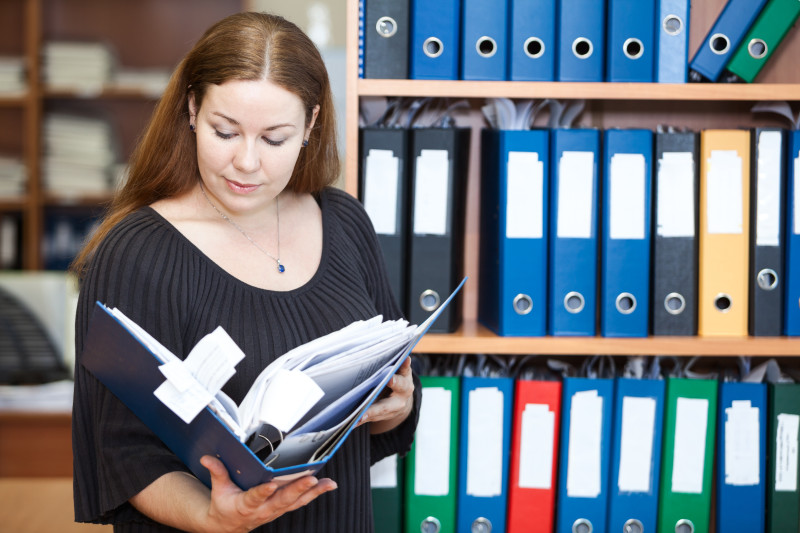 Executive Business Woman Looking At Documents In Folder At Offic