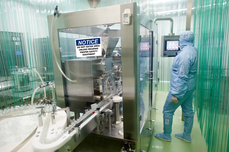 pharmaceutical factory woman worker operating production line at